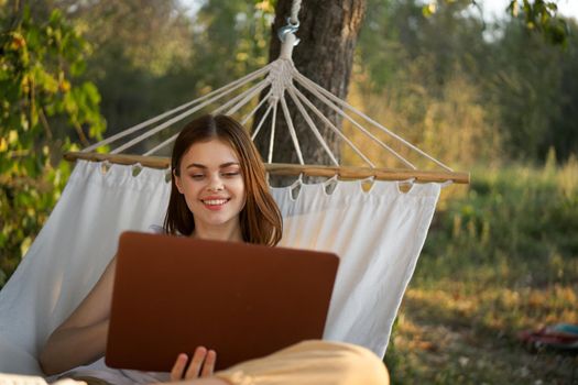 woman with laptop and lies in a hammock vacation nature freelance. High quality photo