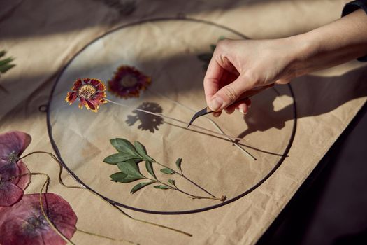 Confident female florist is working with dryed flowers in cozy flower shop