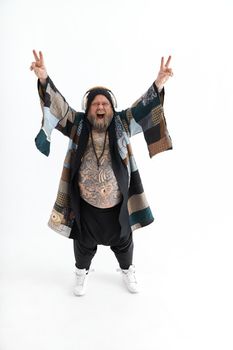 Fat stylish bearded tattoed caucasian man with big belly is posing and dancing wearing ethnic kimono