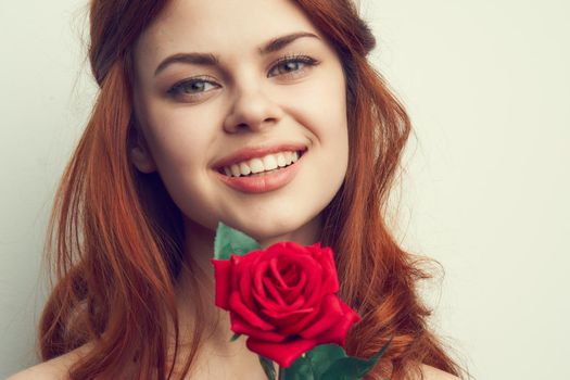 beautiful red-haired woman rose flower close-up charm. High quality photo