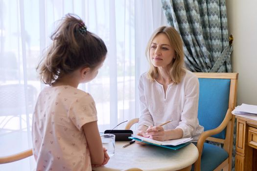 Child girl at session with social worker, school psychologist in an office. Child psychology, professional help, mental health of children, conversation between counselor and preteen girl