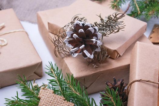 dried fir branch and wooden star with sparkles on a gift box wrapped in eco paper on a gray background and linen fabric top view place for copy eco friendly lifestyle