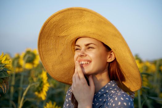 pretty woman with hat in the field of sunflowers freedom nature. High quality photo