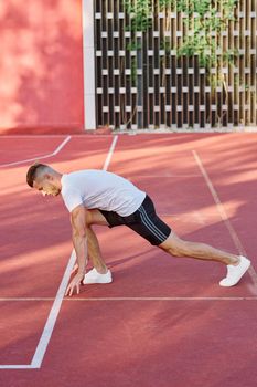 athletic men doing exercises on the sports ground in summer. High quality photo