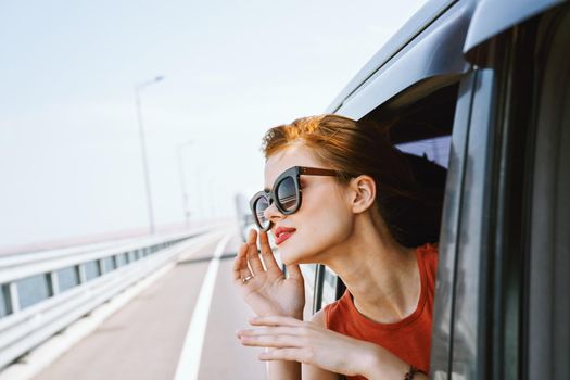 woman looking out of car window wearing sunglasses travel lifestyle. High quality photo