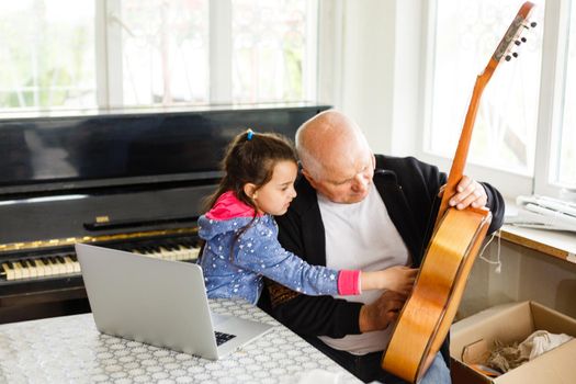 grandfather teach girl playing the piano happily