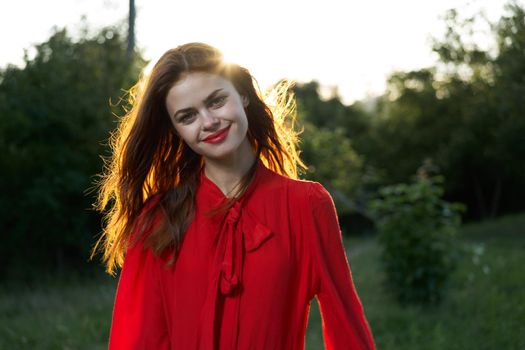 cheerful woman in a red dress in a field outdoors fresh air. High quality photo