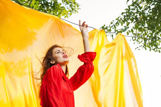 woman in red dress outdoors yellow bedspread. High quality photo