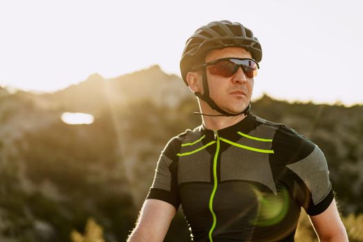 Portrait of male caucasian cyclist with helmet and glasses close up