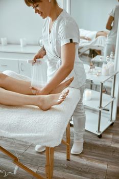 Confident female doctor is doing taping procedure in modenr treatment cabinet