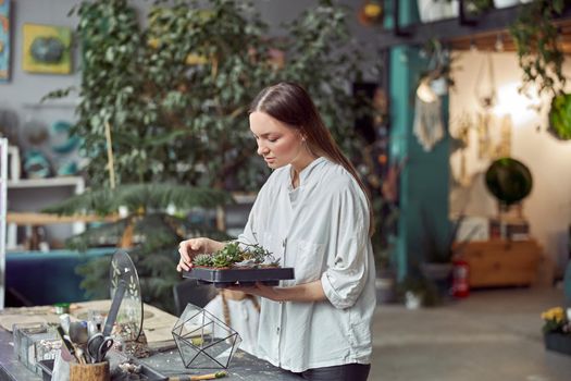 Confident female florist is working with dryed flowers in cozy flower shop