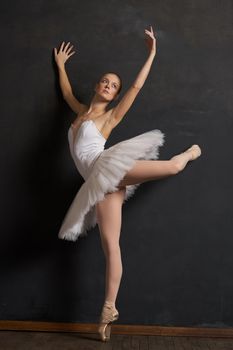 woman ballerina in a white tutu dance posing performance dark background. High quality photo