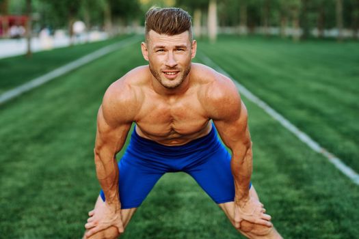 sporty muscular man goes in for sports in the park workout motivation. High quality photo