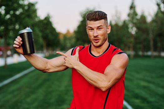 sporty man in red jersey muscle workout park. High quality photo