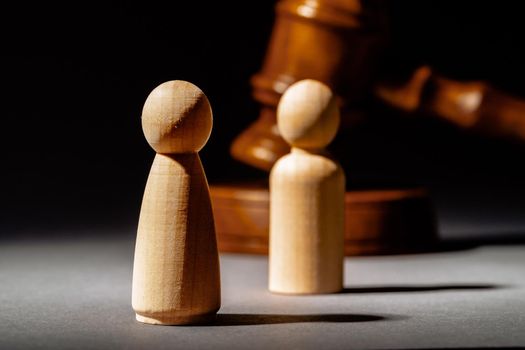 Wooden toy family and judge mallet close up. Family divorce concept
