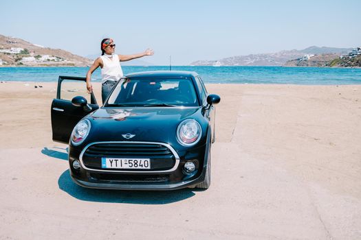 Mykonos Greece April 2018, woman on a road trip, Mini car on the beach during road trip Mykonos Greek Island