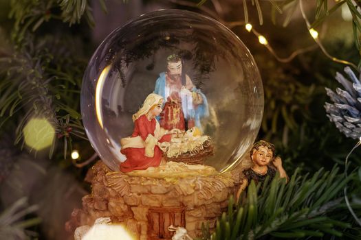 Scene of the nativity of Jesus Christ in a glass ball on a Christmas tree