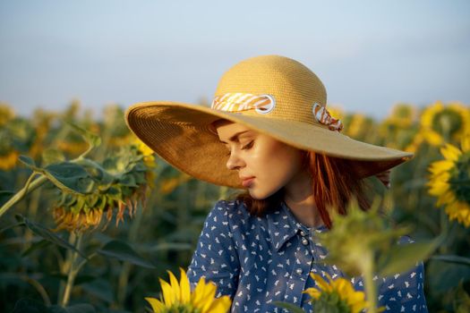 pretty woman with hat in the field of sunflowers freedom nature. High quality photo