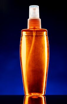 Glass bottle with cosmetic oil on dark background close up