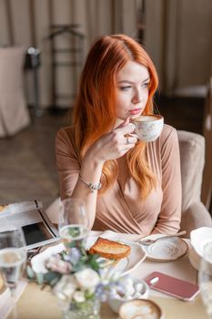 Portrait of a beautiful young elegant blonde woman in the cafe with a glass of champagne