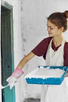 woman painter In white apron home renovation interior. High quality photo