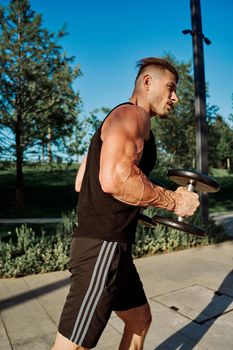 sporty man exercise fitness workout outdoors with dumbbells. High quality photo