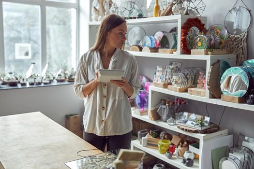 Young caucasian happy seller woman at botanic shop