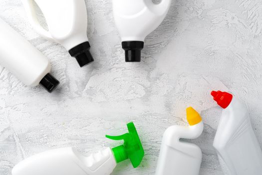 Set of different bottles of liquid detergents top view on grey background