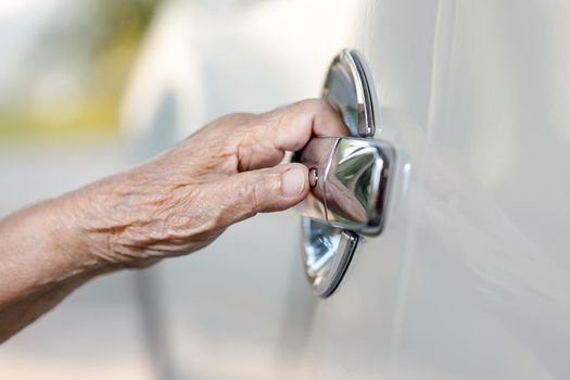 elderly woman hand opening car door