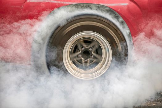 Drag racing car burns rubber off its tires in preparation for the race