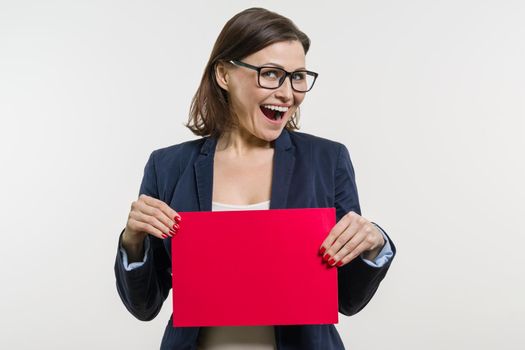 Smiling middle aged woman with red sheet of paper on white background