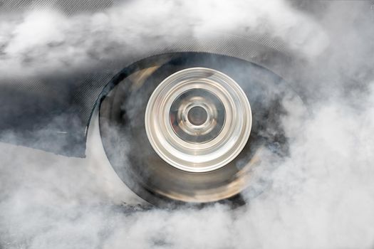 Drag racing car burns rubber off its tires in preparation for the race