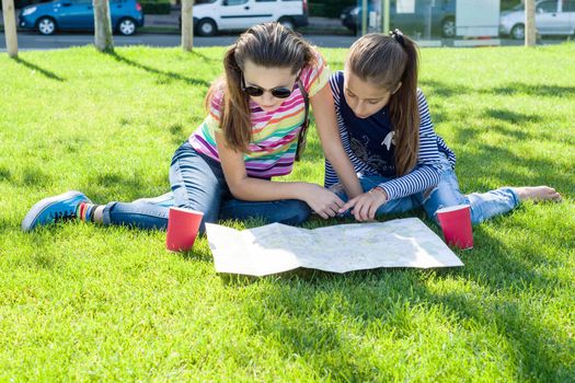 Young cute girls teens with map of european city outdoors, copy space