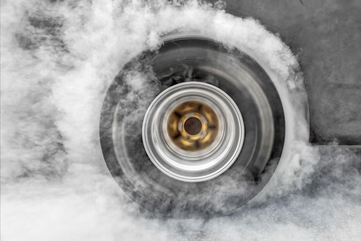 Drag racing car burns rubber off its tires in preparation for the race