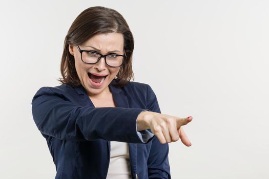 Angry mature businesswoman screaming, white studio background