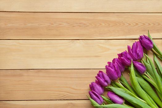 red Spring Tulip Flowers on wooden table. Blooming spring petals. Beautiful red Tulips in spring. Tulip flower with green leafs on wooden background. spring day for postcard