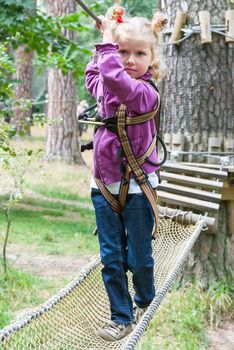 Child 4 years old in adventure climbing high wire park, active lifestyle of children