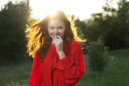 cheerful woman in a red dress in a field outdoors fresh air. High quality photo