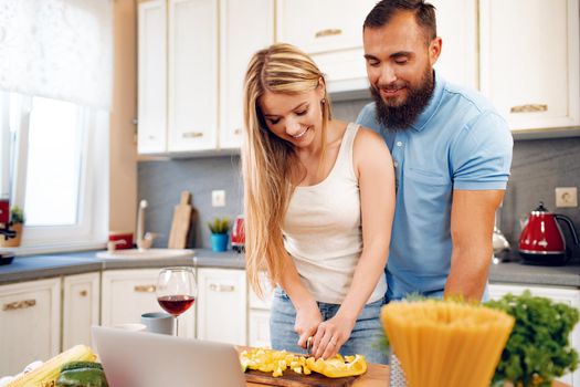 Young loving couple cooking together in kitchen at home