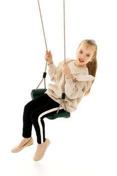 School-age teenage girl swinging on a swing. The concept of rest after class. Isolated on white background.