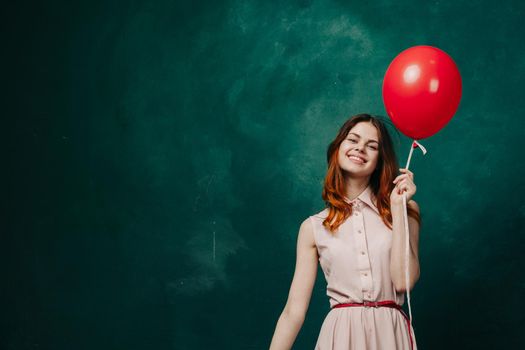 cheerful woman with red balloon green background holiday. High quality photo