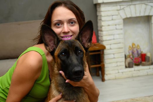 Portrait smiling cute woman with shepherd dog posing while sitting at home