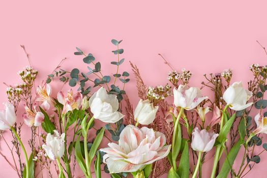White tulips alstroemeria branches and green leaf on pastel pink background with copy space. Sweet and beautiful wallpaper for Valentine or wedding backdrop design