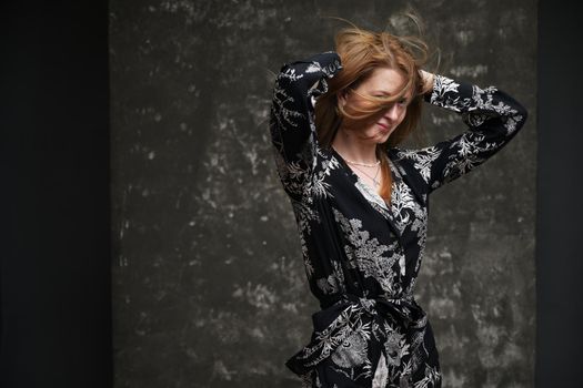 Portrait of a brunette with flying hair on a gray background