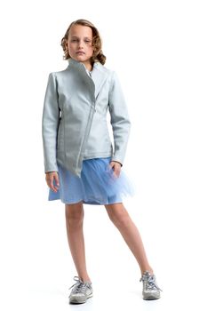 Pretty girl in leather jacket and fluffy skirt. Blonde girl with stylish hairstyle wearing fashionable clothes. Full length portrait of preteen child posing in studio against white background