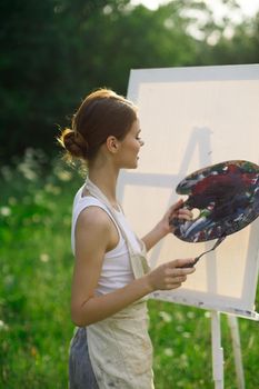 woman artist outdoors paint palette painting landscape. High quality photo