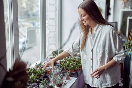 Caucasian female florist is taking care about her plants