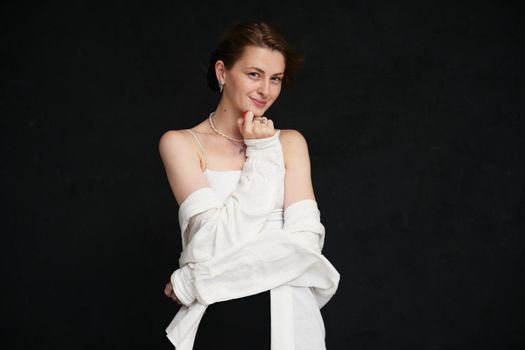 beautiful woman smiling on a black background in the studio in a light top