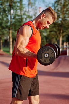 Muscled Man With Dumbbells Outdoor Workout. High quality photo