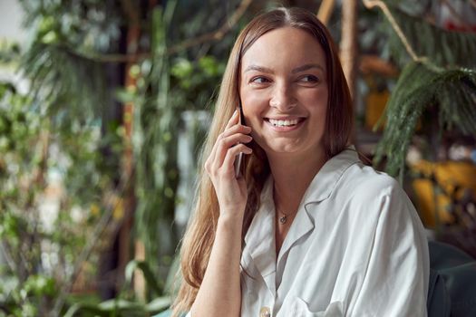 Young caucasian happy seller woman at botanic shop